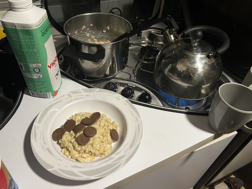 A bowl of porridge, a carton of milk and a pot and a kettle on a stove for the MIUT 85k race report
