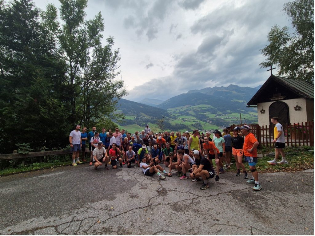 A large group of runners sitting and standing to pose for the camera before their shakeout run at adidas TERREX Infinite Trails in Gastein