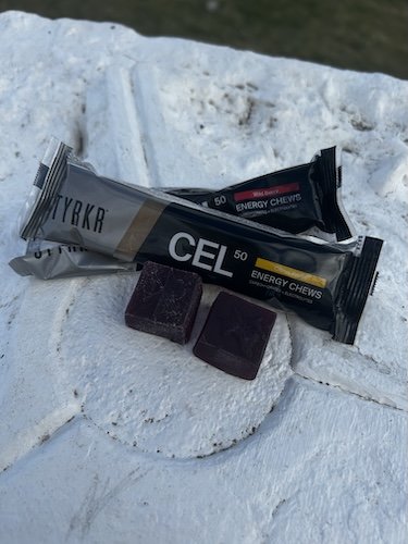 Opened STYRKR CEL50 energy chew packets and individual chews resting on snow